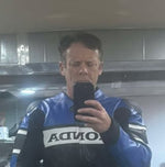 Person wearing a blue and black motorcycle suit with 'ACTIVA' branding in a room.