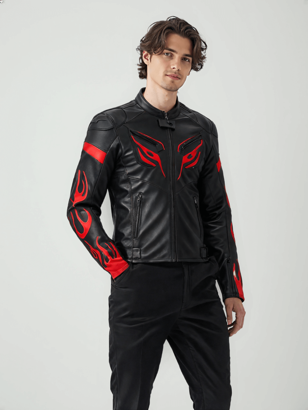 Close-up of the chest area of a black leather motorcycle jacket, highlighting the red tribal eye-like design and sleek stitching details.

