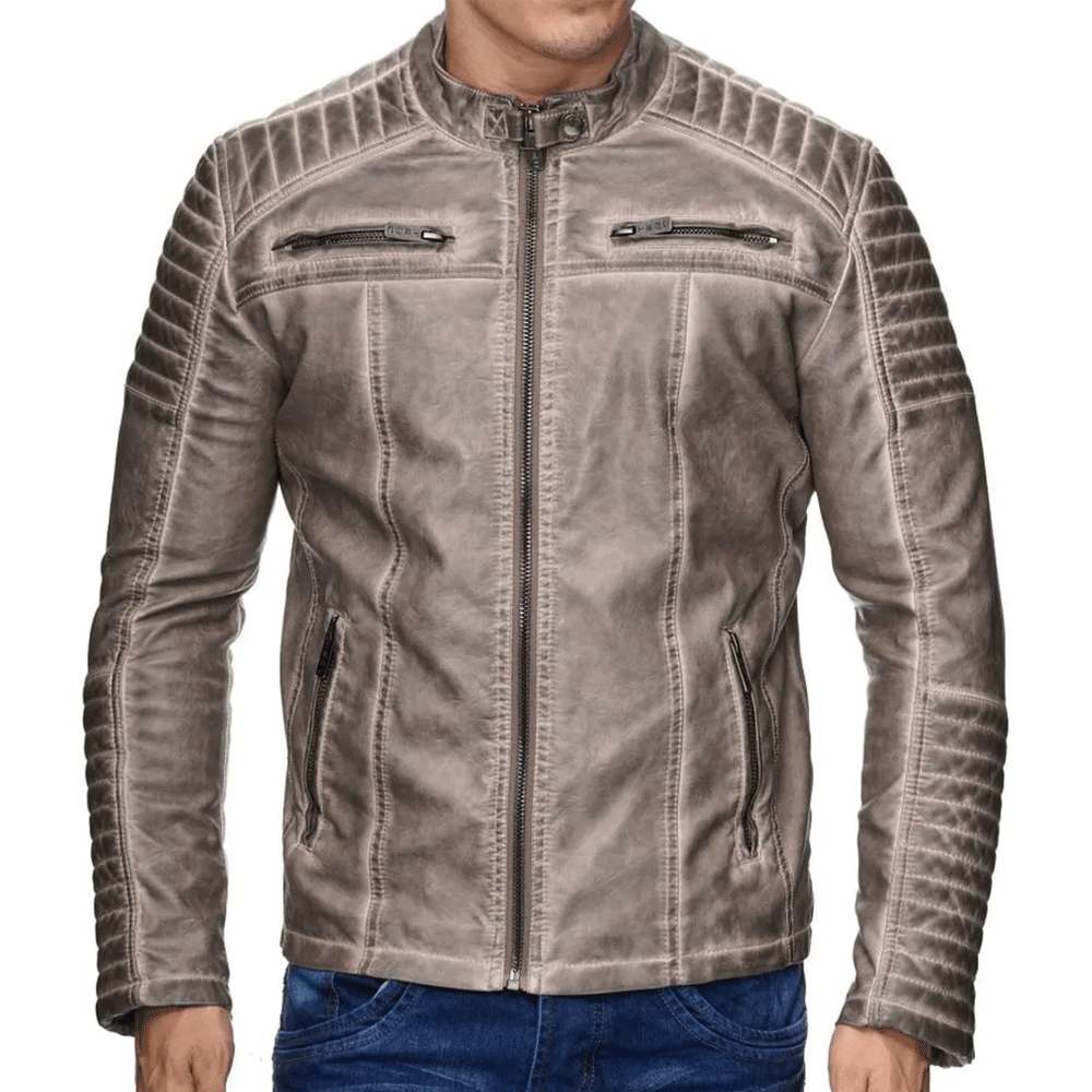 A man wearing a beige leather motorcycle jacket with a mandarin collar, zipper details, and embroidered patches on the arms and back.
