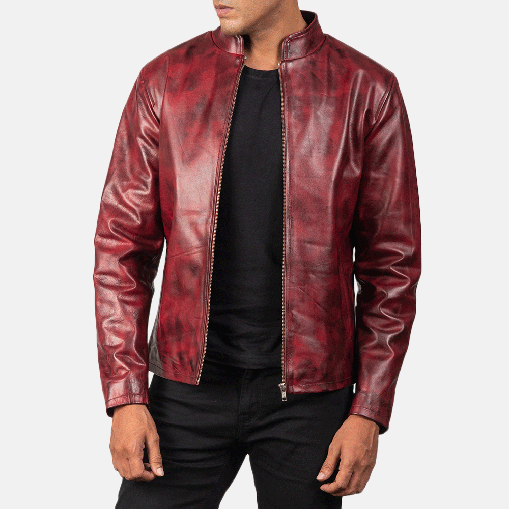 A man wearing a red leather motorcycle jacket with a zipper and embroidered details, paired with black pants.