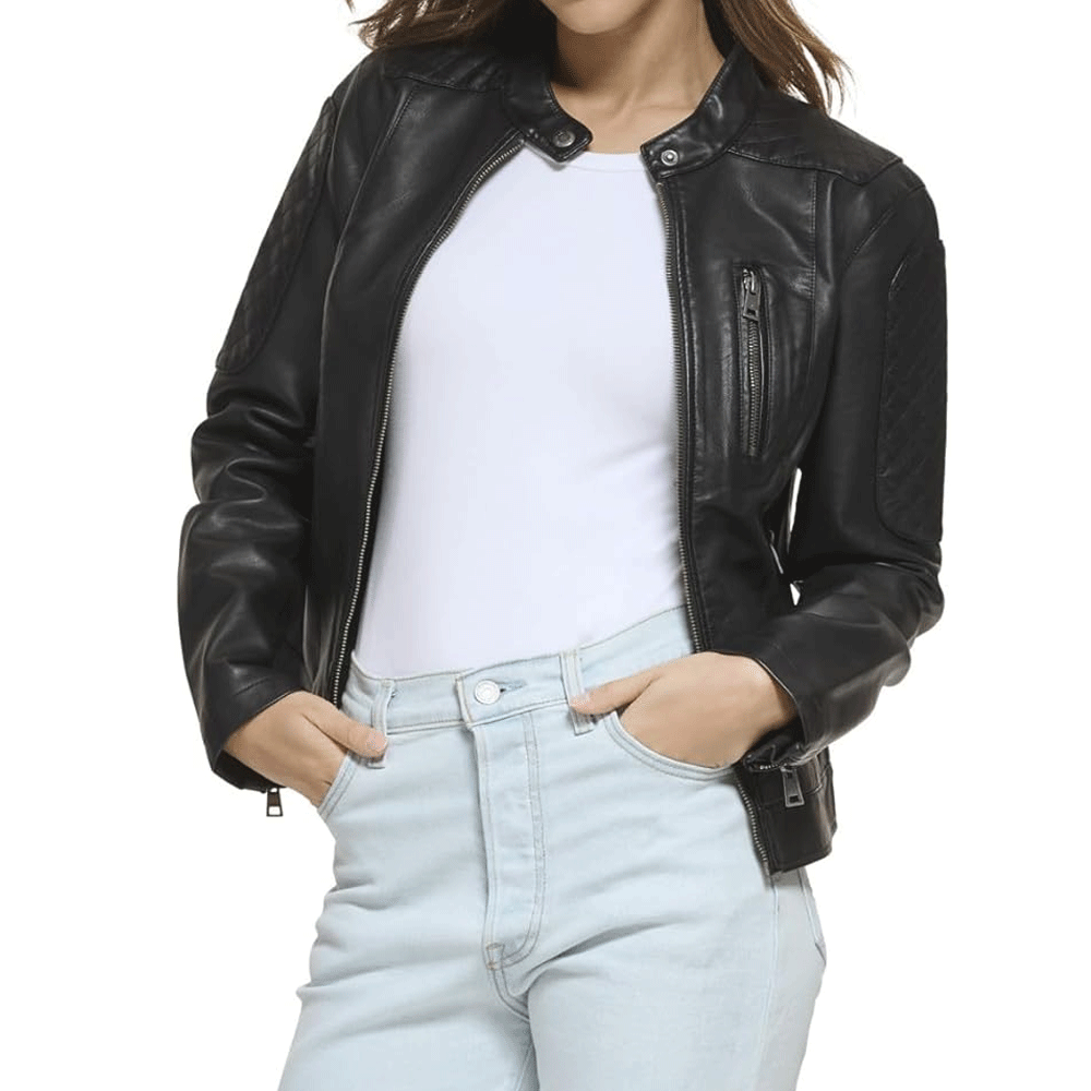 A woman wearing a black leather motorcycle jacket with a mandarin collar and YKK zipper, paired with light blue denim jeans.